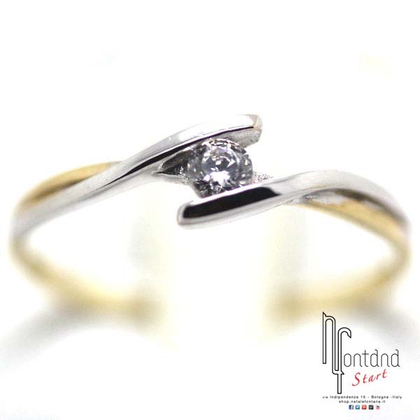 Anello solitario contrariè in oro bianco e giallo con doppio gambo che abbraccia zircone bianco